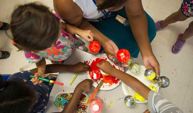 PLASP staff and children painting Styrofoam balls 