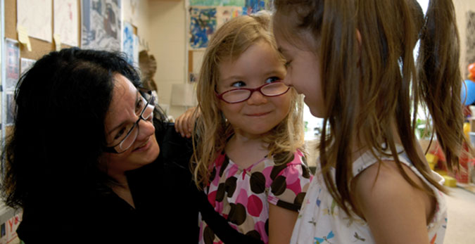 A PLASP staff member with two children