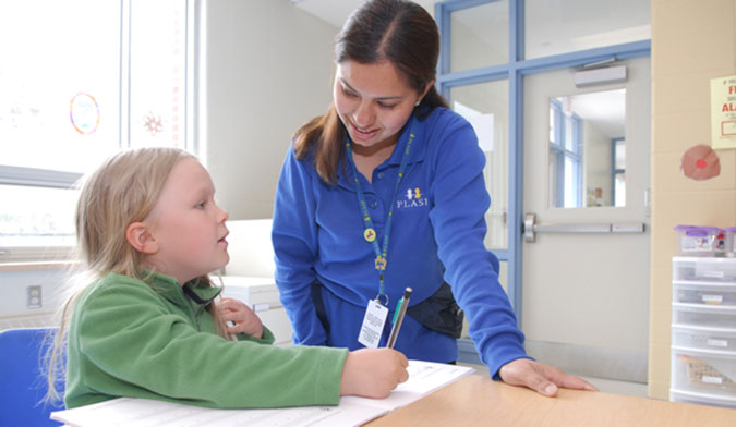 A PLASP staff member helping a child 