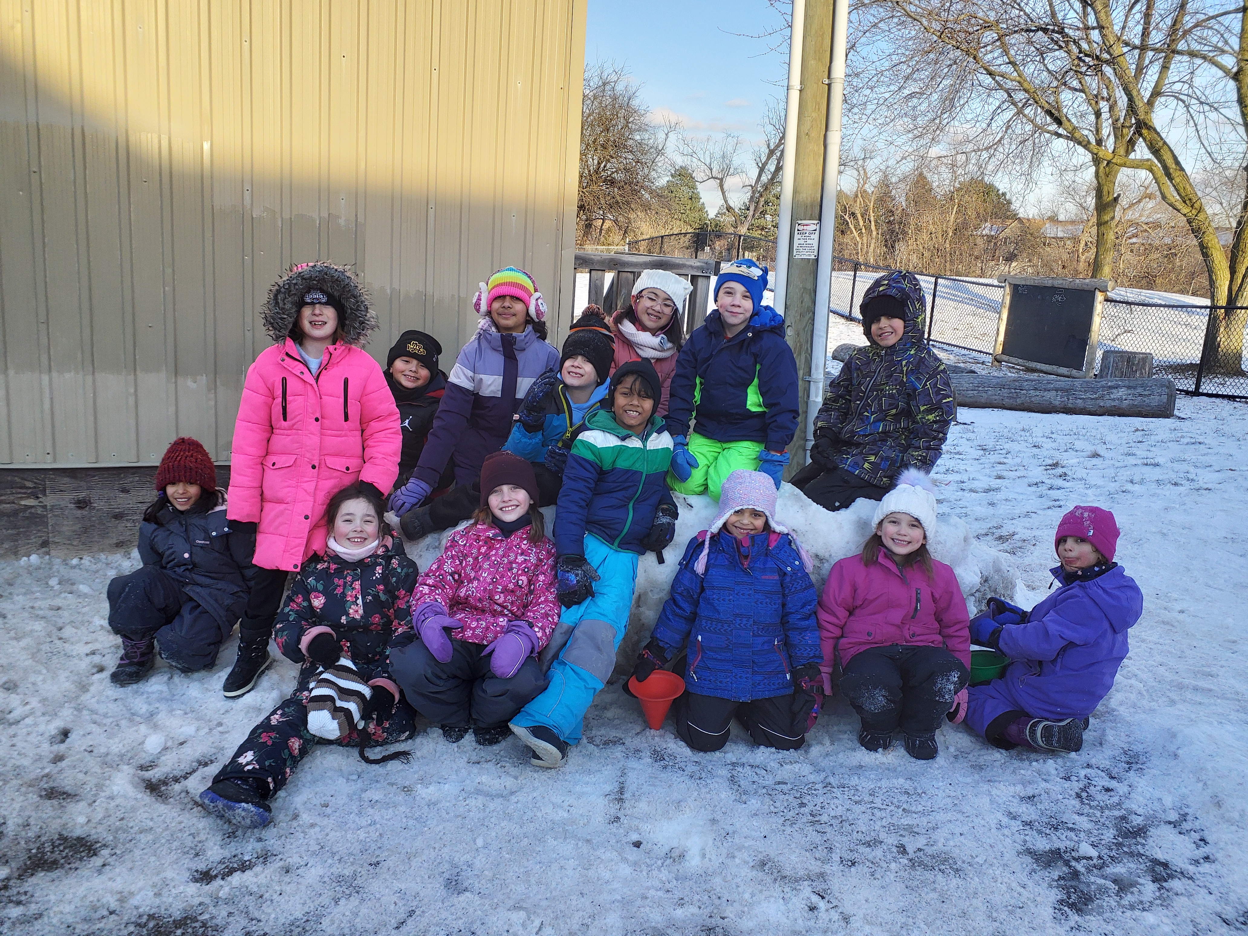 A group of PLASP friends sitting in the snow 