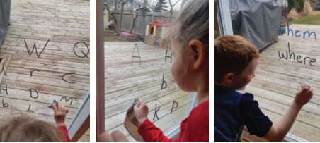 Children using cloths to wipe marker letters off glass