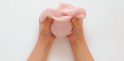 Child's hands playing with pink goop